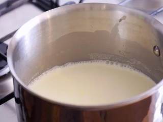 黑芝麻冰淇淋,汤锅中倒入100毫升奶油，牛奶，开火煮混合物即将沸腾即可关火