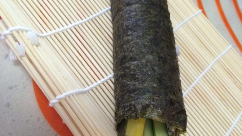 寿司,从卷帘的一侧顺势卷起，卷的时候用力，切的时候才不会散。