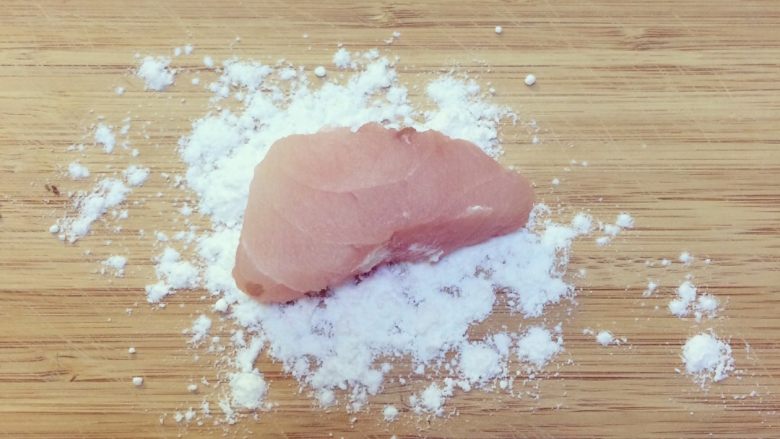 温州敲鱼汤,案板上撒少许淀粉，取一块鱼肉裹上淀粉.