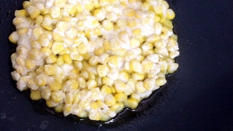 玉米烙,锅中放油倒入玉米粒，用铲子按平