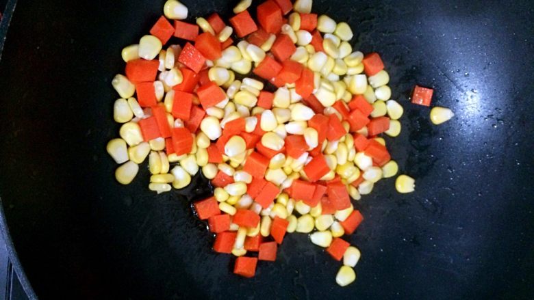 彩蔬丁,热锅凉油，倒入胡萝卜粒和玉米翻炒