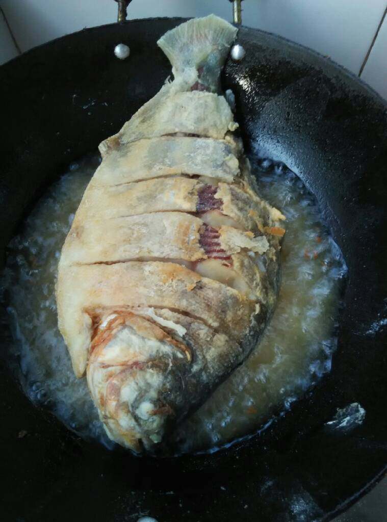 红烧白鲳鱼,锅里倒油烧热将鱼放入两面炸制金黄