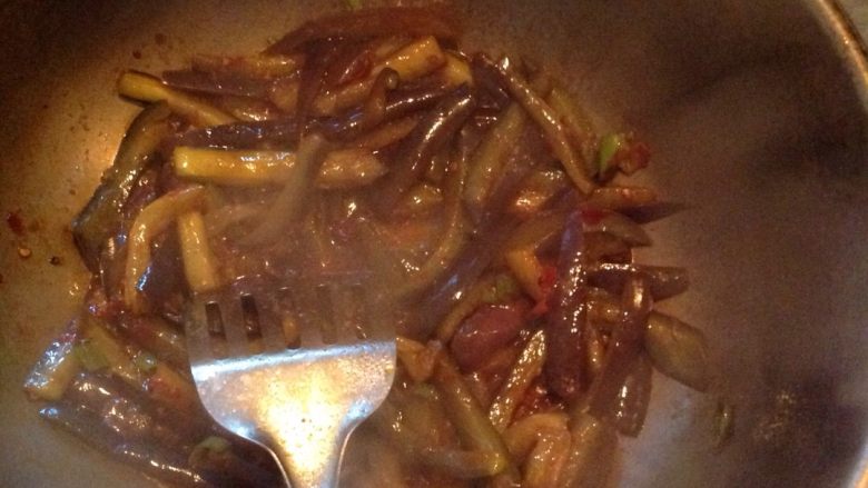炒茄条,锅内倒入适量的油，放入2勺豆瓣酱，炒香，倒入茄条翻炒