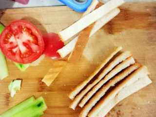 三明治配沙拉,将面包的四边深色部分切掉备用，将黄瓜切长片，西红柿切片