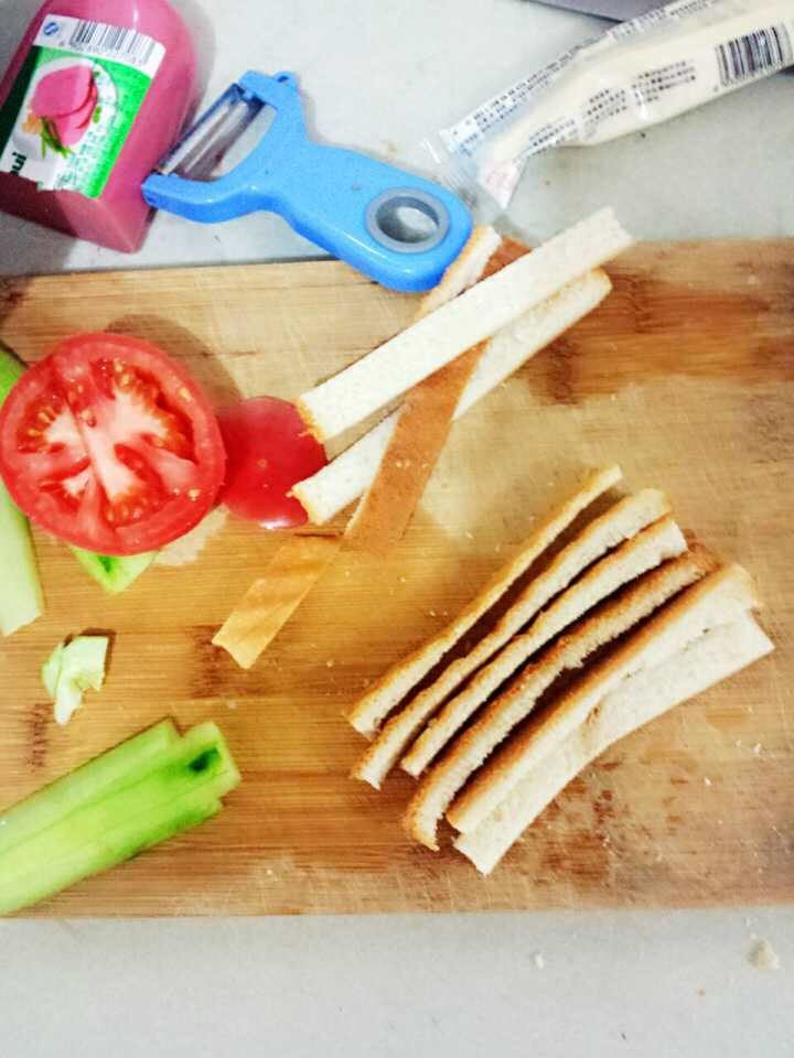 三明治配沙拉,将面包的四边深色部分切掉备用，将黄瓜切长片，西红柿切片