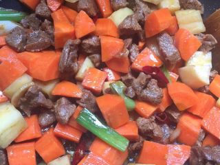 胡萝卜土豆炖牛肉,7:翻炒均匀倒入胡萝卜和土豆继续翻炒均匀。