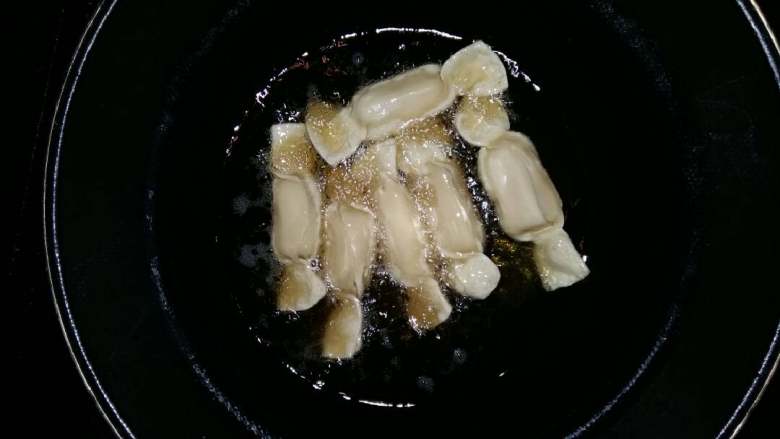 消灭馄饨皮,锅烧热倒入油烧成5成热，倒入已包好的香蕉糖果，中小火慢慢炸止金黄色。