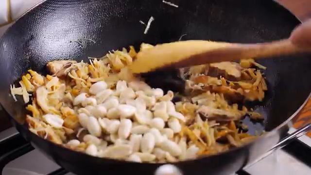 鲜肉粽子,油锅倒油，香菇海米下锅翻炒一会儿，倒入花生翻炒，接着加入生抽、盐、白胡椒粉，调味