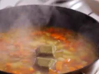 咖喱蛋包饭,倒入日式高汤，小火煮15分钟至蔬菜变软，倒入咖喱块搅拌