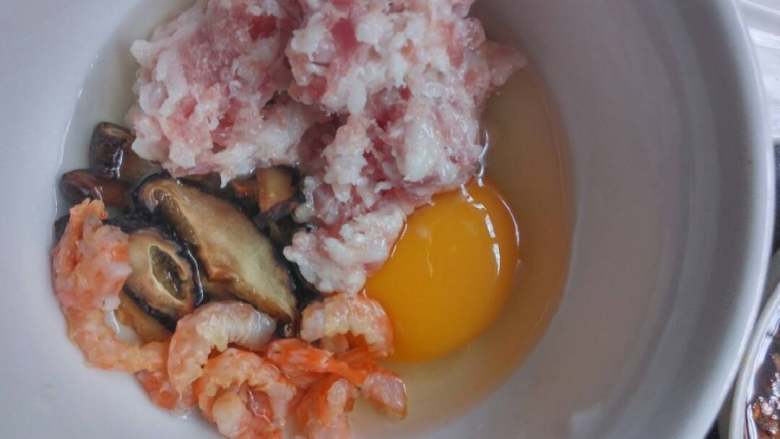 简单家庭版的肠粉,打米浆的同时，将鸡蛋肉末香菇虾米放到碗里