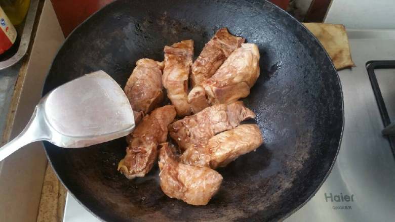 秘制排骨饭,锅中放底油，放入姜丝爆香，下入腌制好的排骨翻炒。