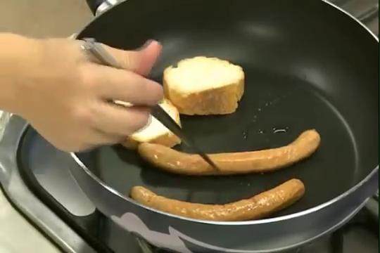 美式早餐與水波蛋,熱鍋放入法國麵包、德國香腸倒入少許的油略煎至兩面微黃後，與作法1的水波蛋，一起盛入盤中。
