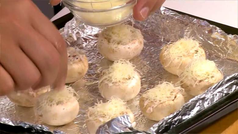 起司烤蘑菇盞,將餡料填入作法1的蘑菇中，撒上少許起司絲，排至烤盤上。