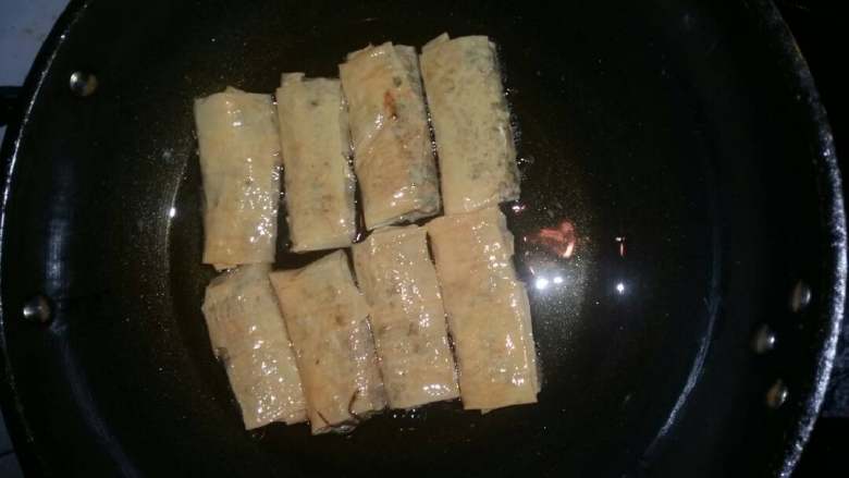 豆腐皮菜卷,锅烧热加油，下豆腐皮包开小火慢慢煎至两面金黄即可出锅。