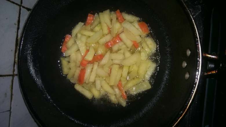 狼牙土豆条,锅烧热倒入色拉油5成热，倒入土豆条和胡萝卜条煸炒。