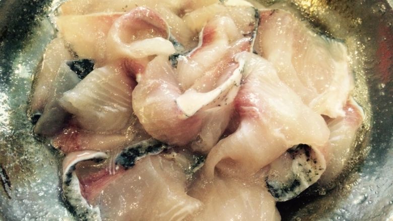 麻辣风味花莲鱼,在事先准备好的鱼肉片（把水倒掉）中放入盐、生粉、蛋清、黄酒，用手轻搅拌，腌制10分钟。