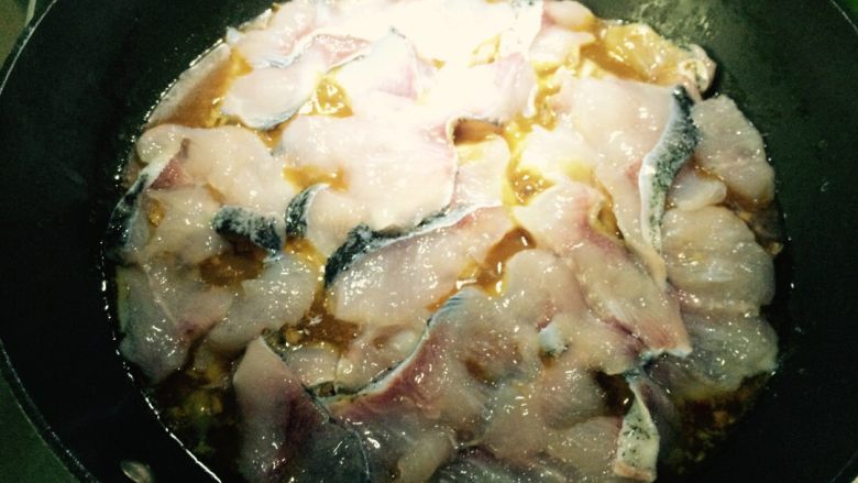 麻辣风味花莲鱼,等锅中鱼骨类烧至八成熟后，调小火，在鱼骨表面放腌好的鱼肉片（一片一片平放）。