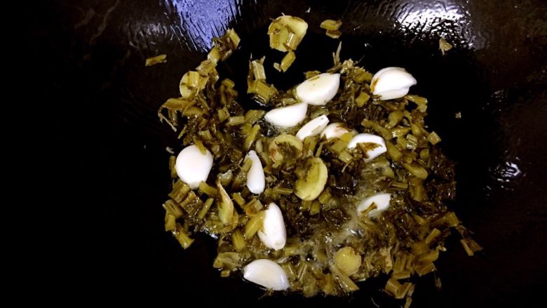 酸菜炖田螺,冷锅热油，下生姜片和大蒜爆香，后下酸菜翻炒片刻。