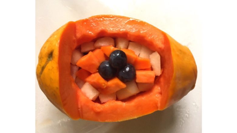 木瓜水果船#甜蜜美味#,把黑加仑葡萄、香梨块、木瓜块摆放在木瓜船里。
