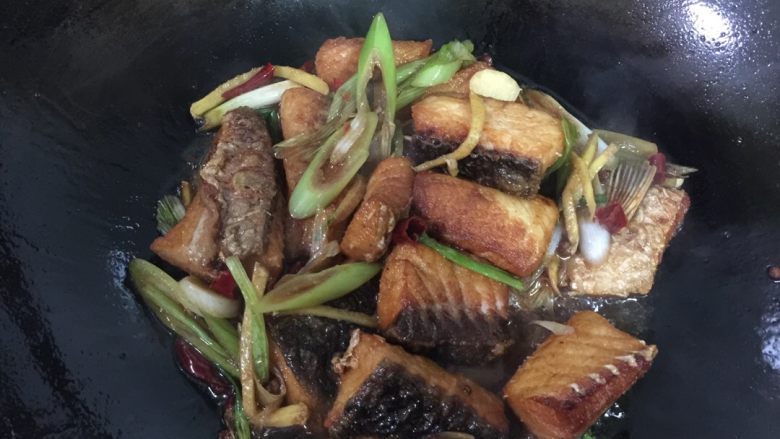 武汉版糍粑鱼,倒入炸好的鱼块翻炒均匀，盖上锅盖焖1分钟（根据水量确定时间，以水刚刚烧干为度）。