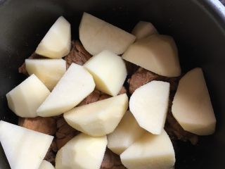 高压锅土豆炖排骨,腌好的排骨上面放上土豆，再撒些盐，（土豆比较吃盐，但是也不能太多）