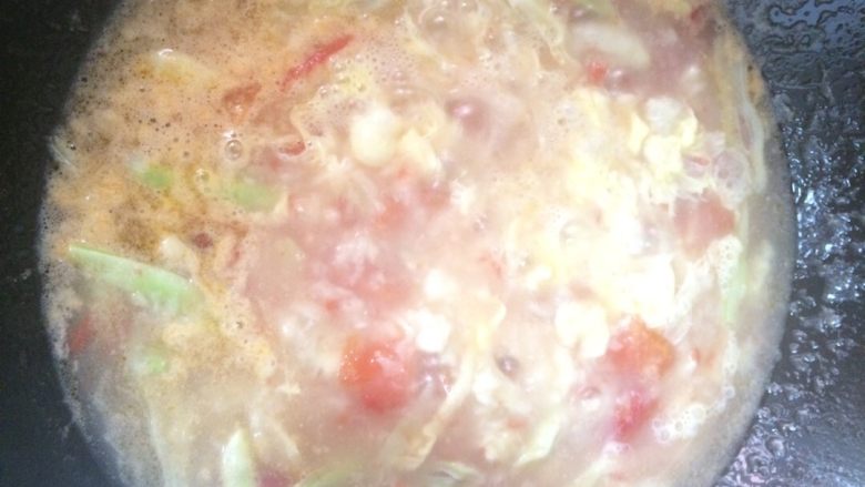 西红柿鸡蛋疙瘩汤,用筷子比住碗，把鸡蛋倒入锅中（拿勺子趁一下锅底，以防止沾锅）