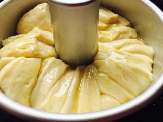 香浓炼乳面包.,剩下的黄油炼乳刷在面包上，撒上杏仁片，烤箱预热180度，中下层烤18分钟左右.