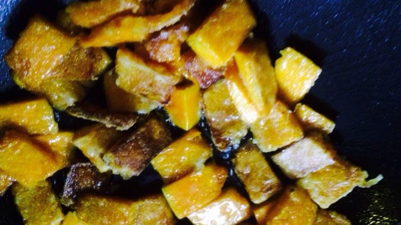 咸蛋黄焗南瓜,油锅里倒油，将裹好玉米淀粉的南瓜在油锅里煎一下，7分熟样子，盛出备用。
