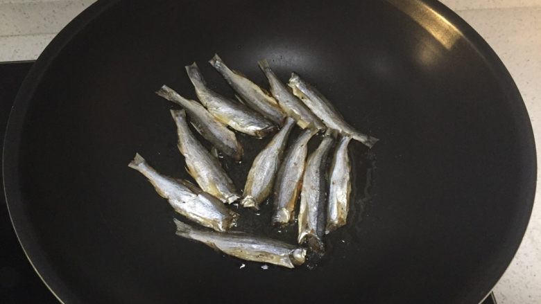 香煎小鱼干,热锅冷油，放鱼干入锅，煎一会儿