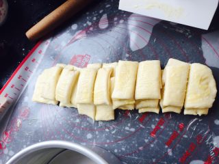 香浓炼乳面包.,面条一条条叠起来，中间切开，一共切成8块，模具抹上少许黄油.放入面团