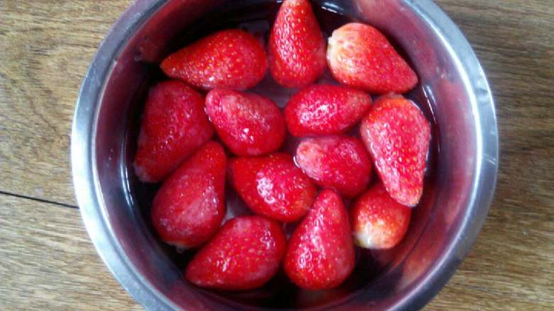 冻草莓#甜蜜美味#,将清洗干净的草莓放入糖水中，浸泡5分钟。