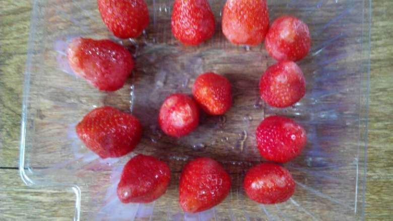 冻草莓#甜蜜美味#,捞出草莓，沥去水分，摆到容器里，放入冰箱冷冻。
