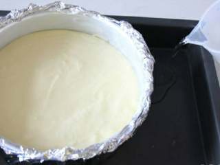 轻乳酪芝士蛋糕
,将拌好的蛋糕糊倒入之前准备好的蛋糕模具里，模具放深烤盘里，倒入3厘米高度的冷水