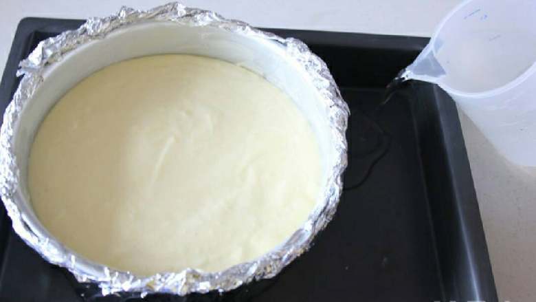 轻乳酪芝士蛋糕
,将拌好的蛋糕糊倒入之前准备好的蛋糕模具里，模具放深烤盘里，倒入3厘米高度的冷水