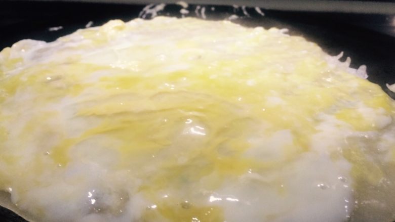 小葱煎饼,把鸡蛋搅碎分布在面饼表面。