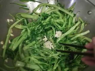 椒丝腐乳炒通菜,很快通菜就变得软软绿绿的，就换上用筷子来炒，这时候加入腐乳再加少许盐拿筷子来拌匀。