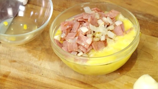 玉米火腿炒蛋,炒好的洋葱火腿丁倒入鸡蛋中拌匀