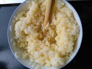 时蔬腊肠炒饭,将米饭加入搅好的鸡蛋里，米饭与蛋液搅拌均匀