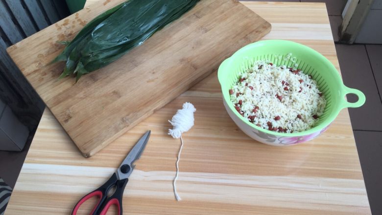红豆粽子,先把粽叶用水烧一个开，沥水备用！糯米和红豆用漏斗的小盆儿沥一下，准备好剪刀，马上就开始啦！