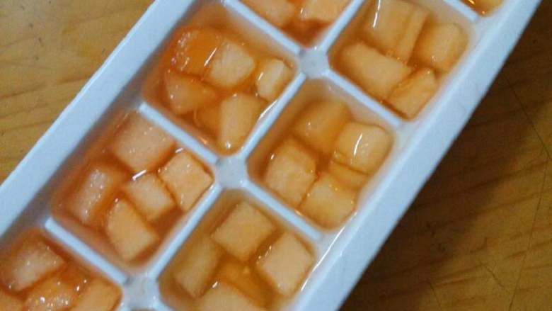 蜜瓜遇上冰,把刚才的哈蜜瓜丁分别放入冰格，加入蜂蜜水，放进冰箱冷冻一夜
