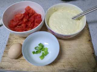 美味疙瘩汤,面粉放入碗水，打入一个鸡蛋，加水搅拌，使之成为面糊
西红柿洗净用开水烫下，去皮，切成片
葱洗净切成葱花

