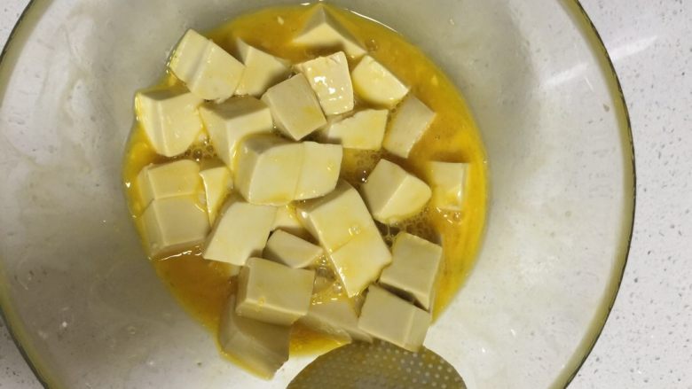 蛋黄豆腐,<a style='color:red;display:inline-block;' href='/shicai/ 9'>鸡蛋</a>打打入碗里搅散，豆腐切块，再加入适量的盐鸡精，用塑料铲搅拌均匀