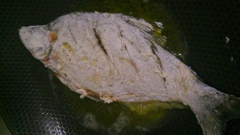 糖醋鱼,鱼切花刀，先用盐和酱油腌制，再裹上一层面糊放入油锅炸至焦脆。