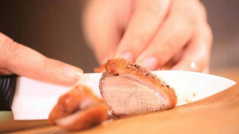 法式香橙煎鸭胸 ,取出烤好的鸭胸肉，切成片，摆入盘中。