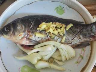 红烧鲫鱼,把鱼🐠身划成平行四边形，撒上盐和酱油，腌好，准备配菜，荞头用刀拍扁