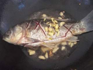 红烧鲫鱼,锅烧热后倒入油，把鱼和姜放入锅中剪