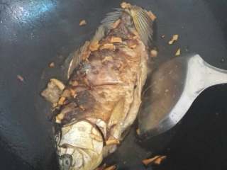 红烧鲫鱼,把底下的鱼煎好后，注意翻身不要用力，慢慢翻好，锅左右摇晃，以便煎至鱼的全身