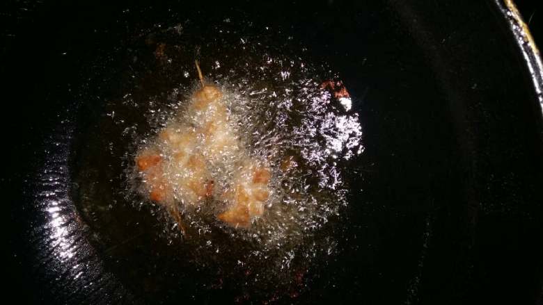 炸里脊串,锅烧热倒入油，中小火投入里脊串慢慢翻炒，见微黄色即可。