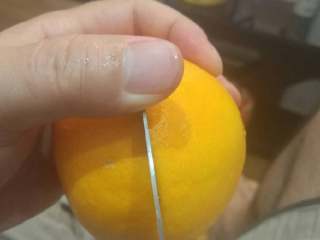 手剥甜橙,橙子洗净后，用手均匀揉捏下它的四周。然后，用水果刀从橙子中部浅浅的切一个圈，深度刚好与外皮厚度一致。