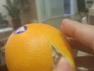 手剥甜橙,左手拿橙，右手拇指探进切口